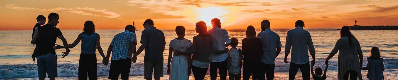 Families watching a sunset from the beach.